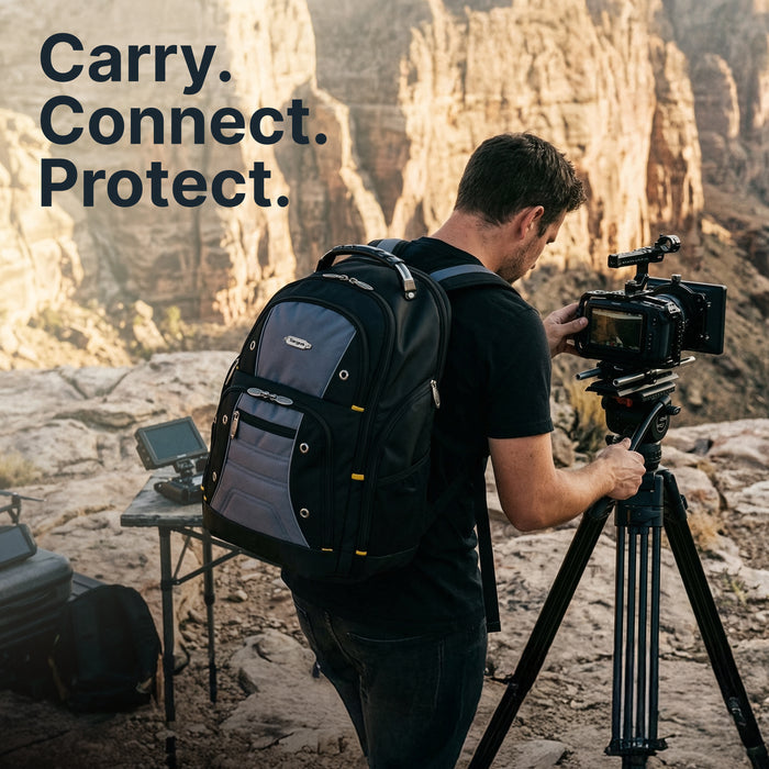 Videographer wearing the Targus Drifter backpack while operating a camera on a tripod at a canyon overlook. Text overlay reads: "Carry. Connect. Protect."