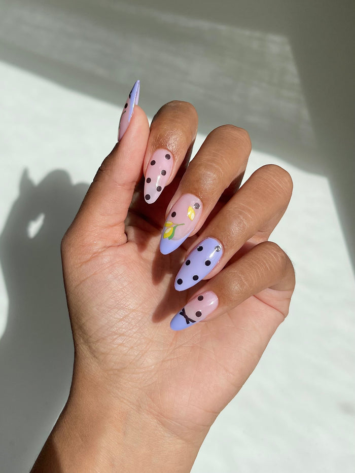Polka dot and lemon stickers on lilac nails
