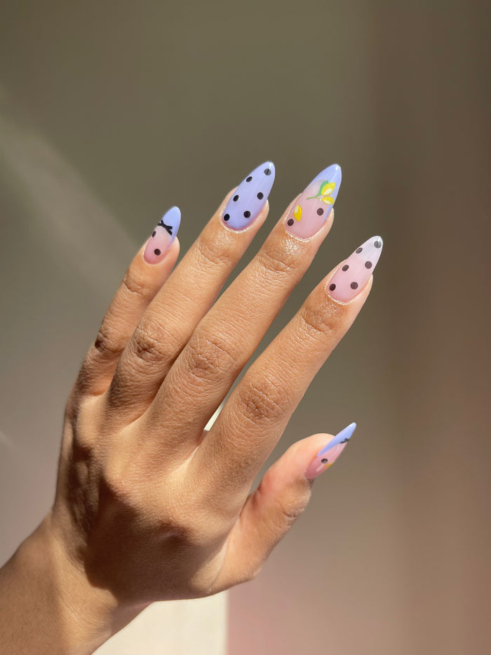 Polka dot and lemon stickers on lilac nails