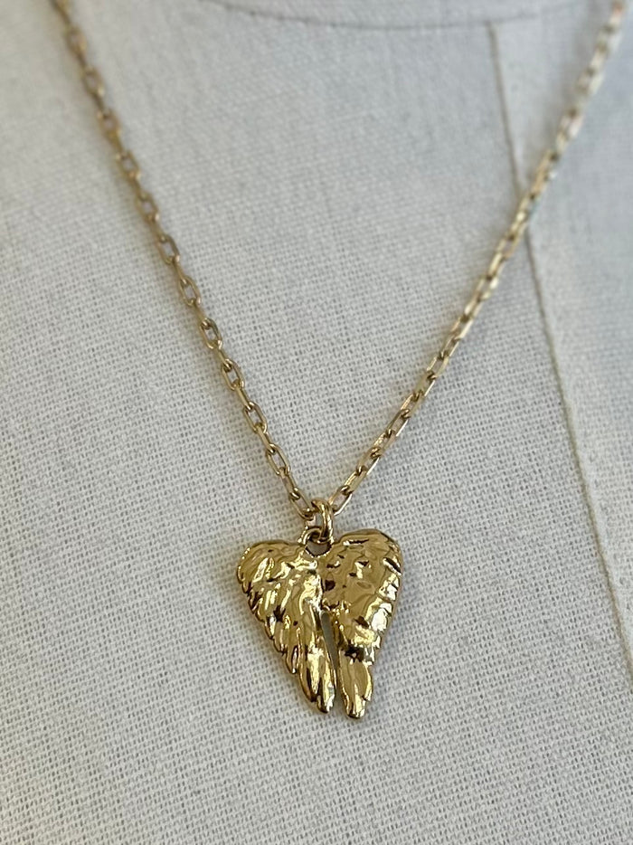 Gold heart-shaped pendant necklace on a light gray background