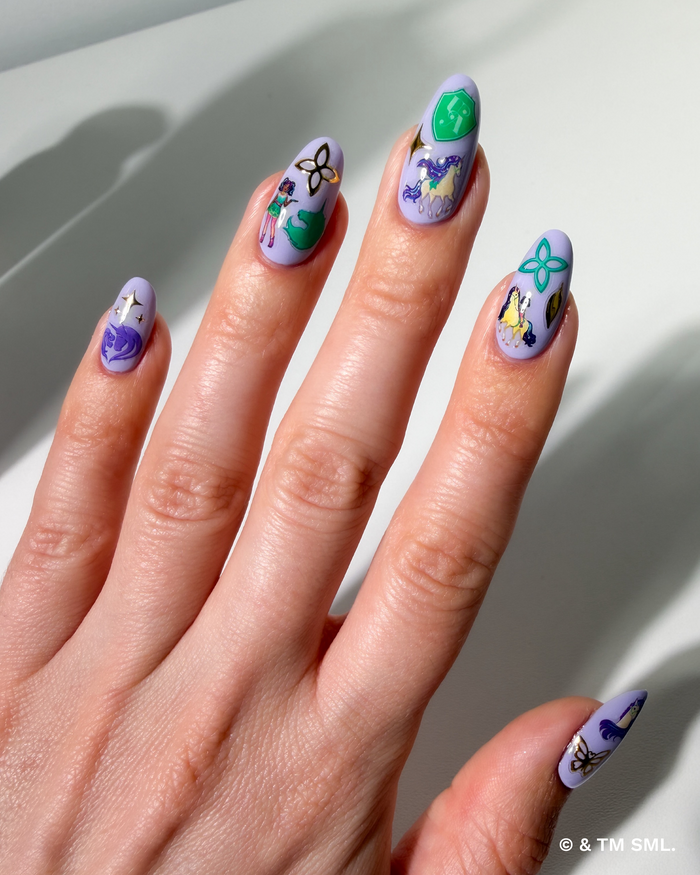 Hand with cartoon stickers on purple nails on a neutral background