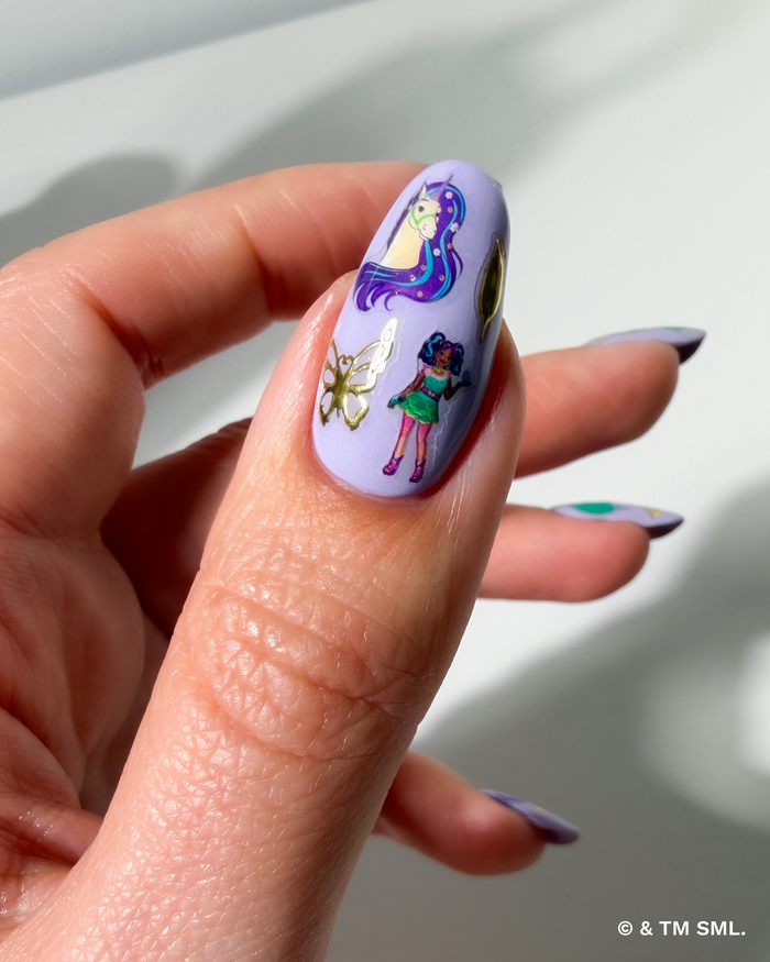 Hand with cartoon stickers on purple nails on a neutral background