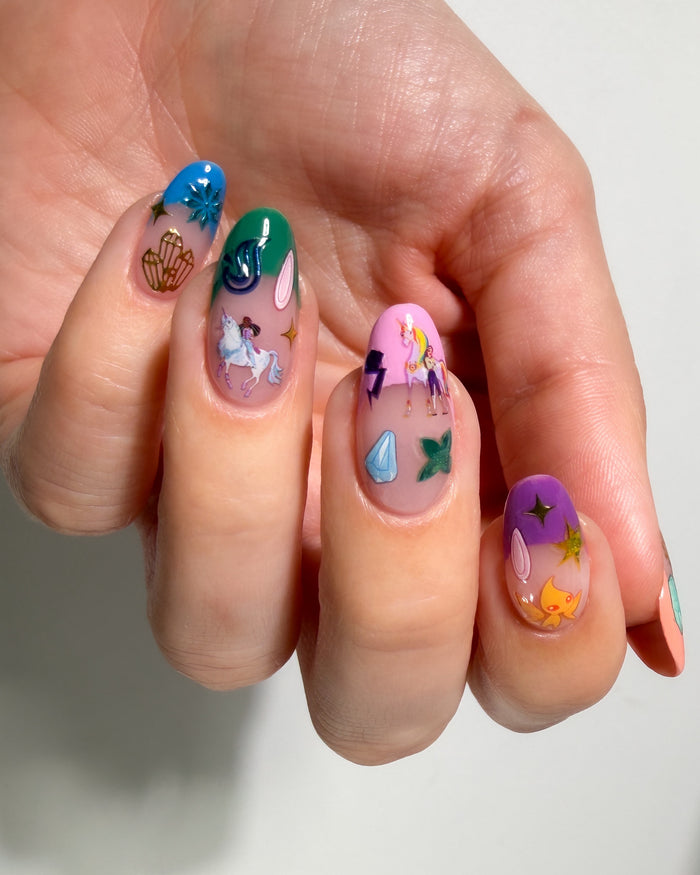 Hand with colorful nail art stickers on a neutral background