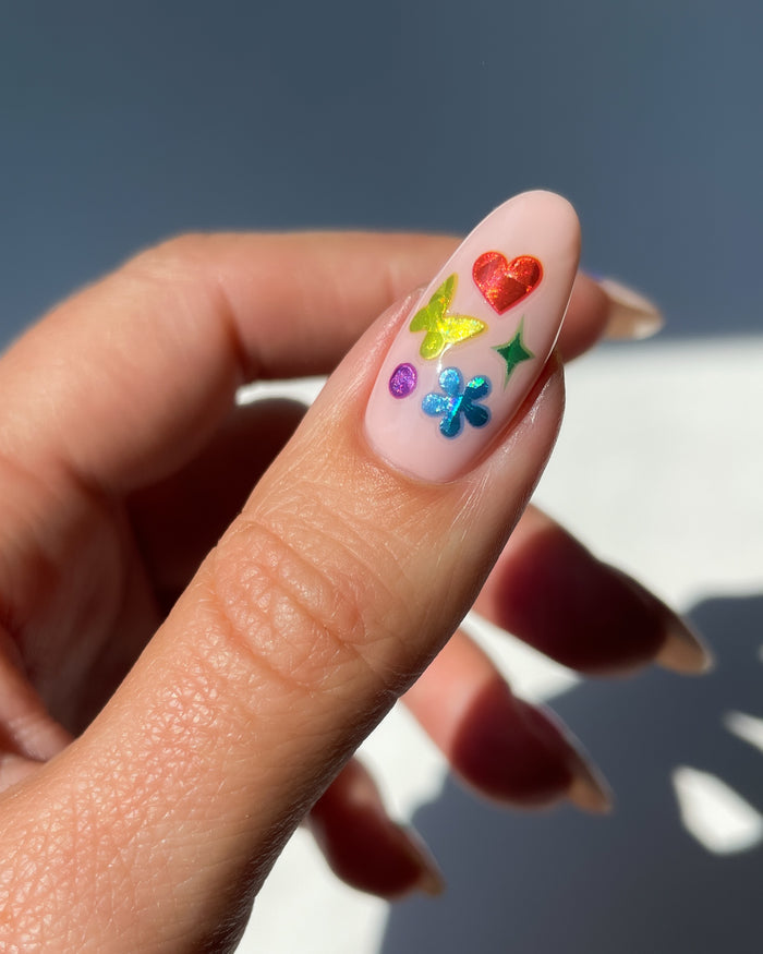 Holo confetti stickers on nude nail, rainbow vibes