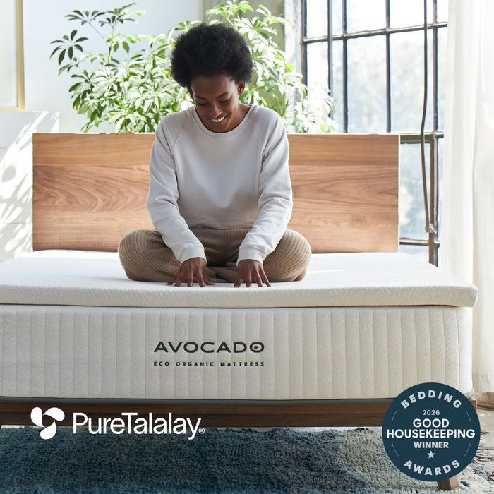 Woman sitting on Avocado Eco Organic Latex Mattress Topper that is Certified GOTS GOLS