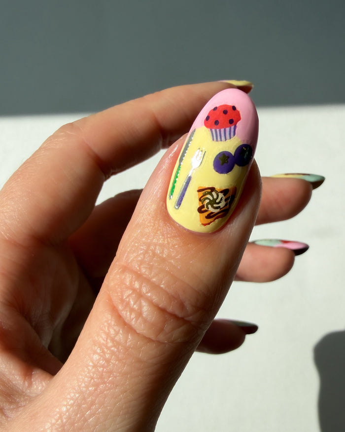 Food nail art stickers on a pastel thumb nail