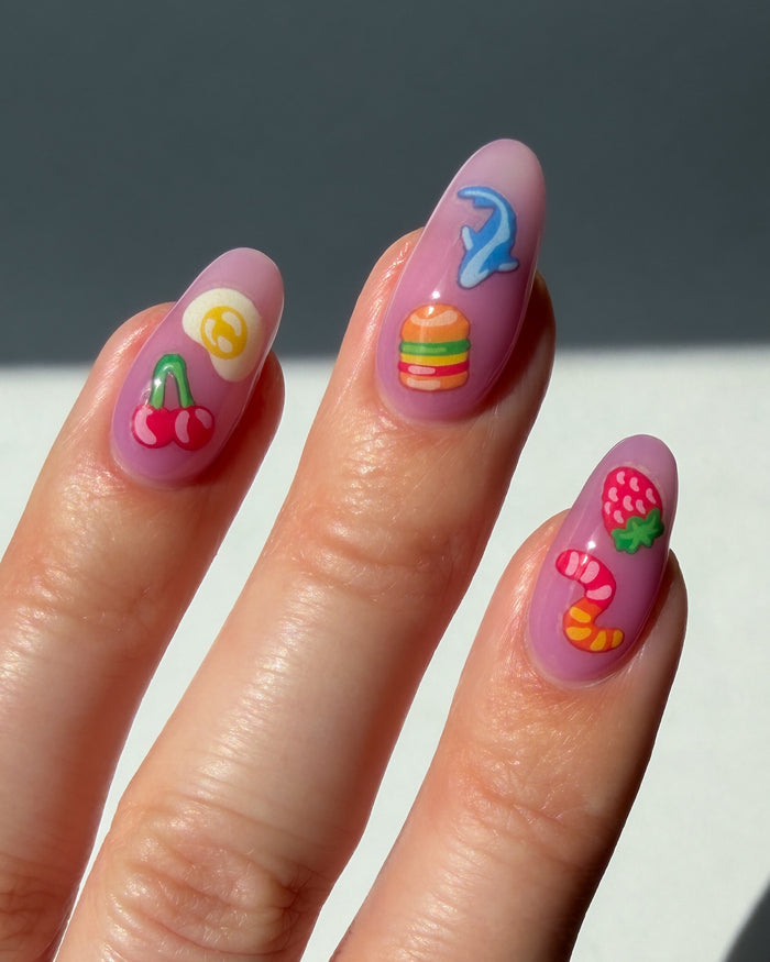 Nails with colorful nail art stickers on a neutral background