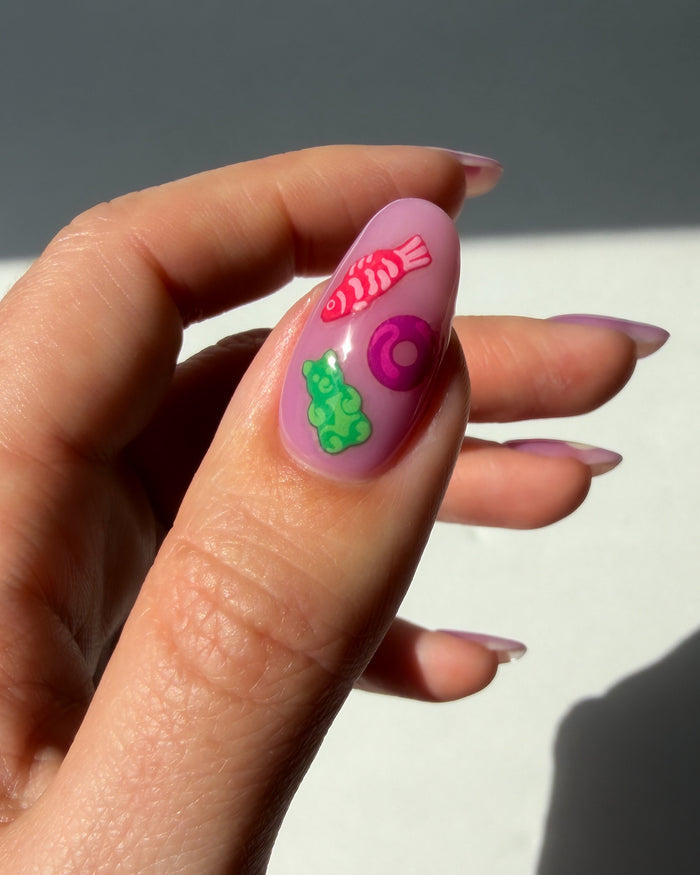 Nail with colorful nail art stickers on neutral background
