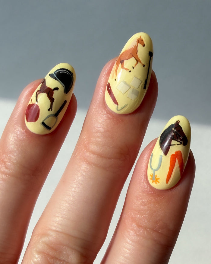 Nails with yellow nail polish and Horse Girl nail art stickers