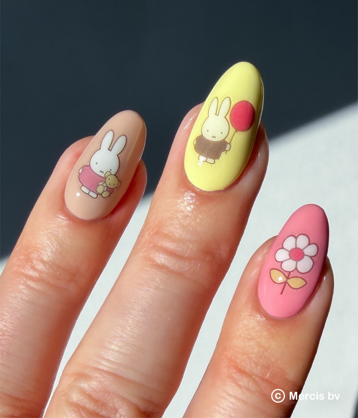 Nails with Miffy nail art stickers on a neutral background