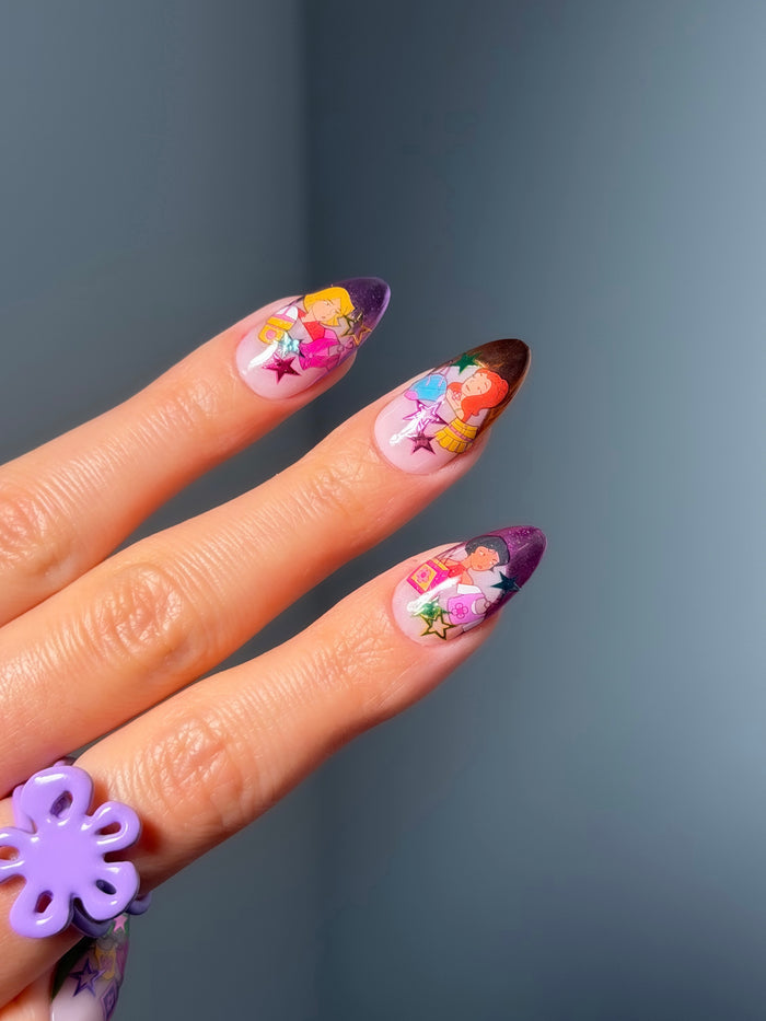Hand with colorful floral nail art stickers on a dark background