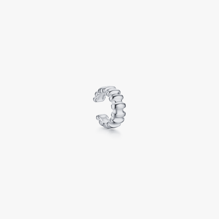 Ribbed Ear Cuff made of stainless steel, featuring a ridged design. Sold individually, it's water safe, tarnish resistant, and suitable for sensitive skin.