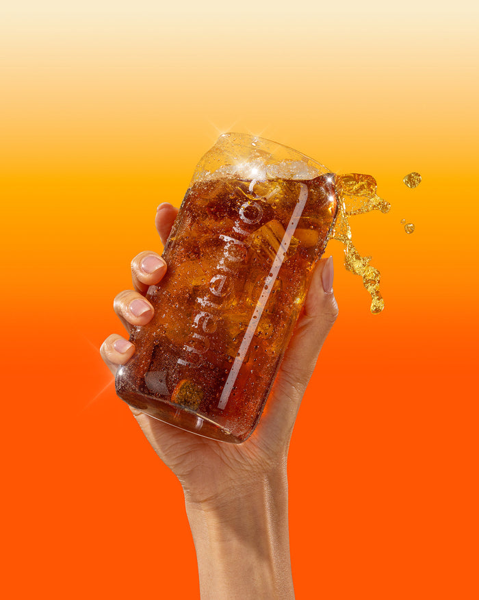 Set s COLA Skleněnou Plechovkou se šplouchnutím perlivého nápoje.