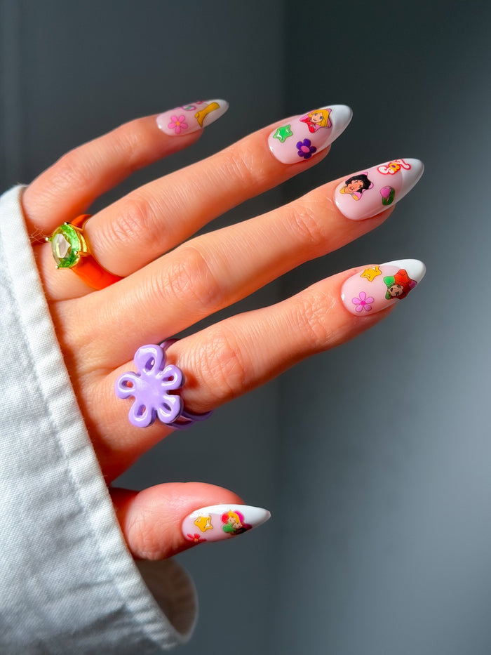 Hand with colorful nail art stickers on a gray background
