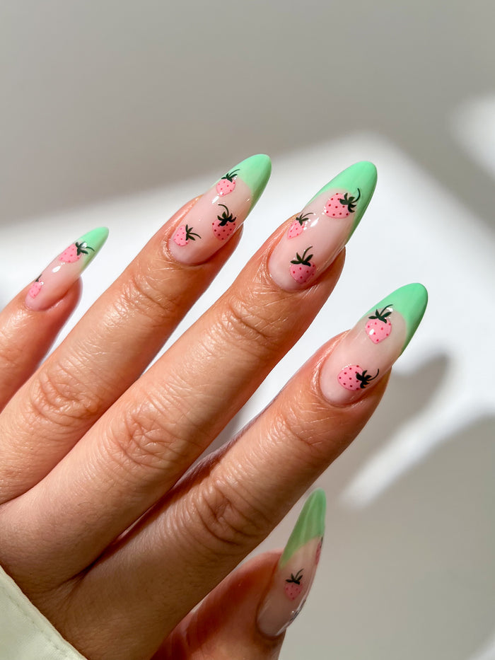 Nails with green french nails and pink strawberry stickers