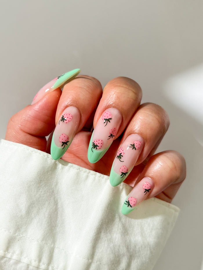 Nails with green french nails and pink strawberry stickers
