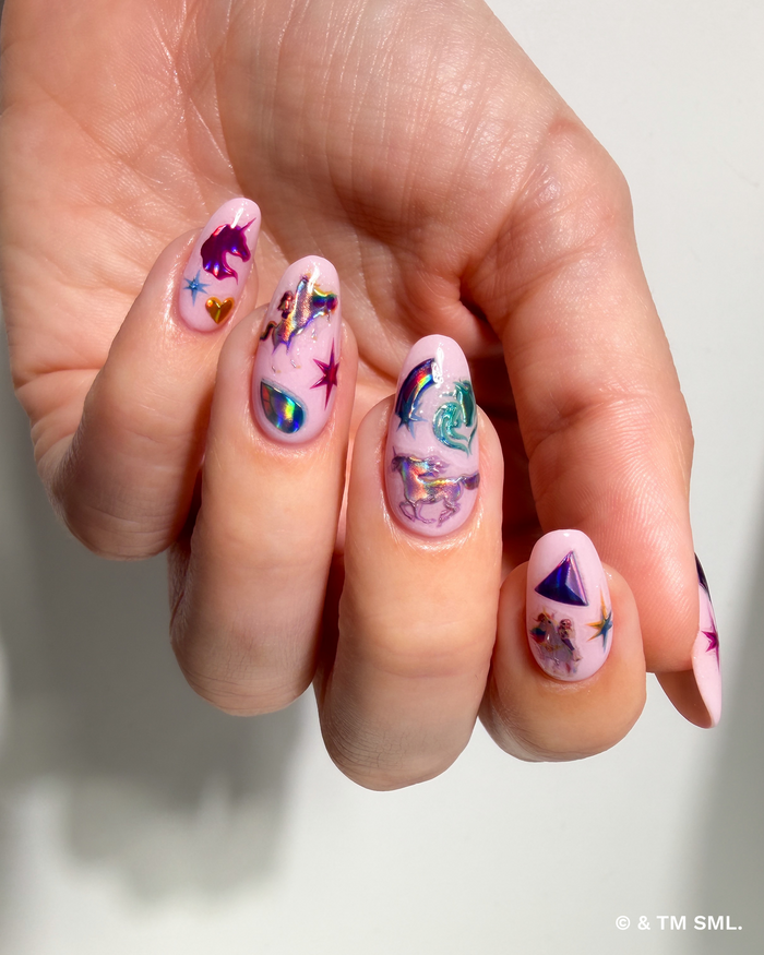 Hand with colorful nail art on a light background