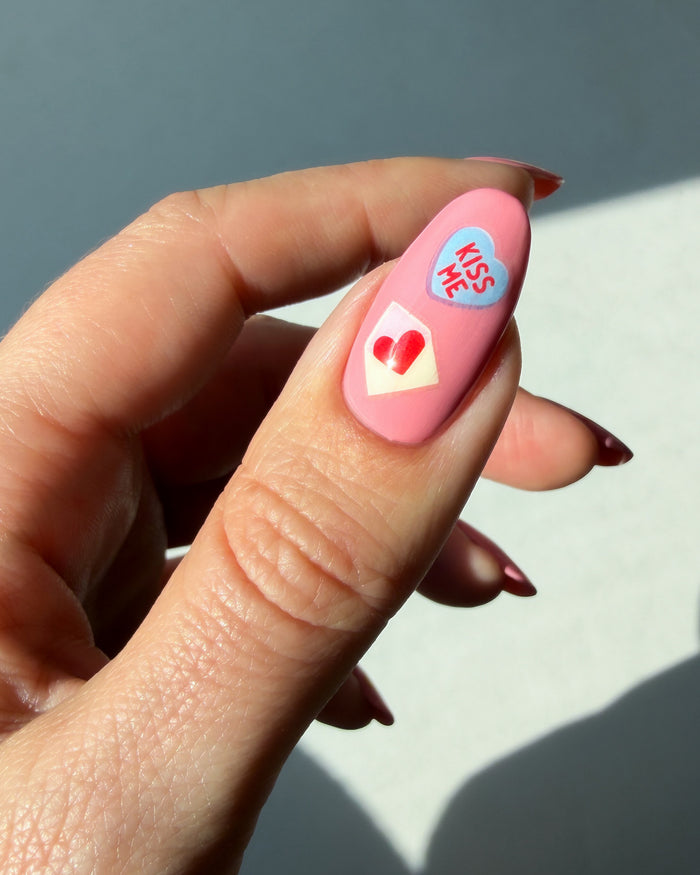 XOXO stickers on pink nail
